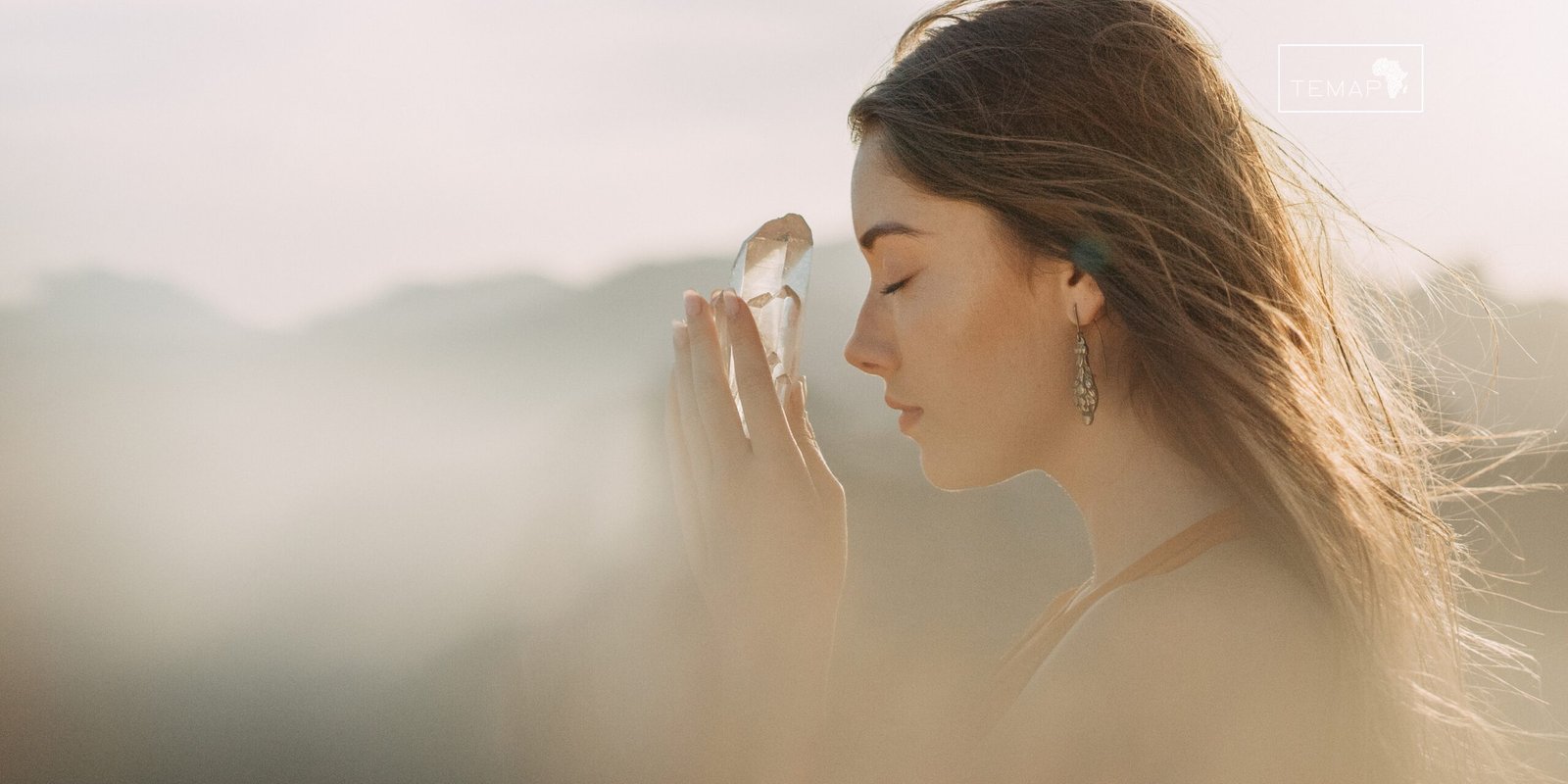 Jovem em meditação com aura espiritual ao fundo, representando conexão mediúnica.